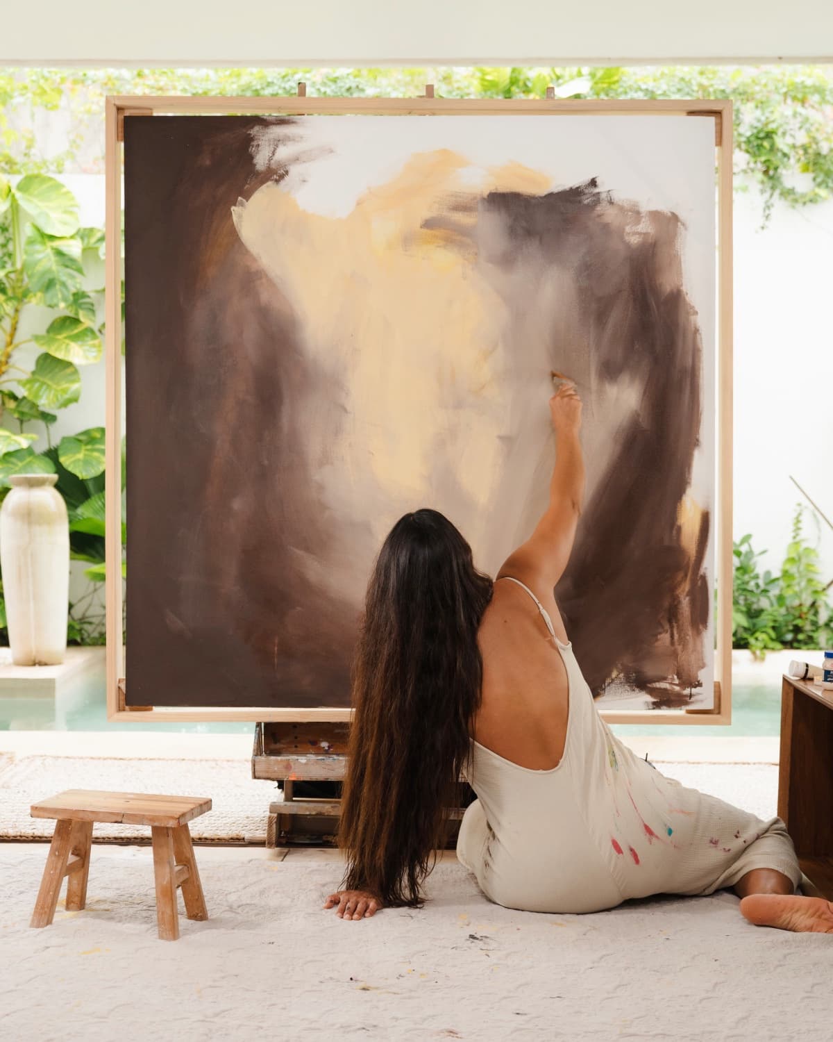 Brenda Uribe pintando un gran formato en su estudio