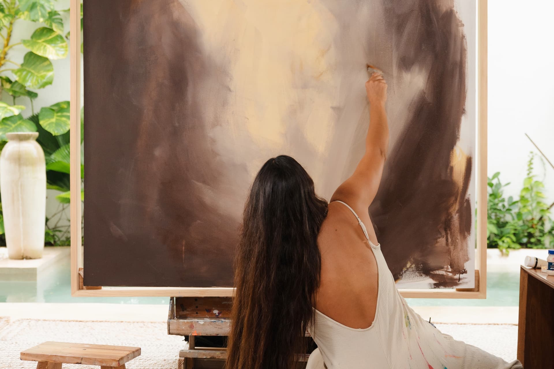 Brenda Uribe pintando un gran formato en su estudio